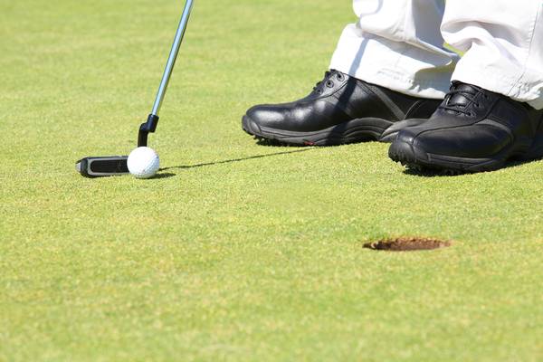 man practicing golf putting