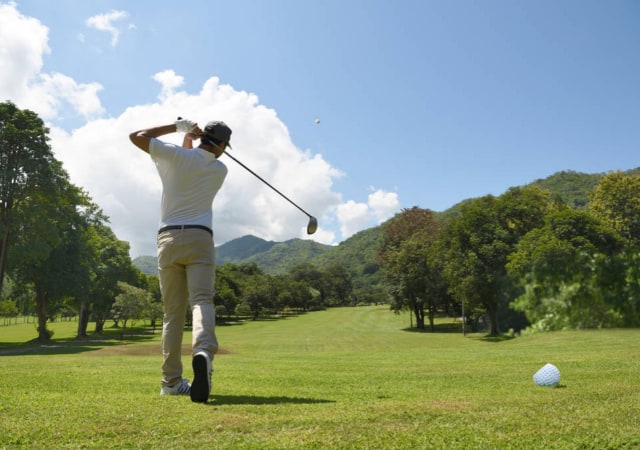 A man swinging a golf club on a golf course
