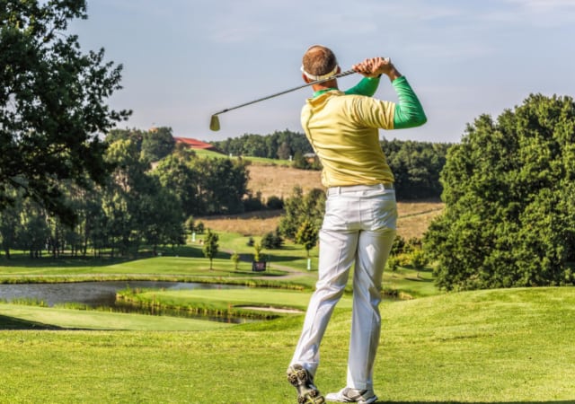 A male golfer on the golf course performing a golf swing