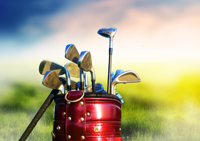 A set of golf clubs in a golf bad placed in the outdoors