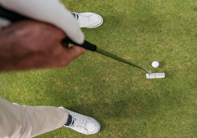 Golfer holding a golf club preparing to swing his club on the golf course