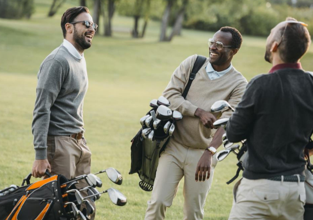 Golfers laughing in front of each other.